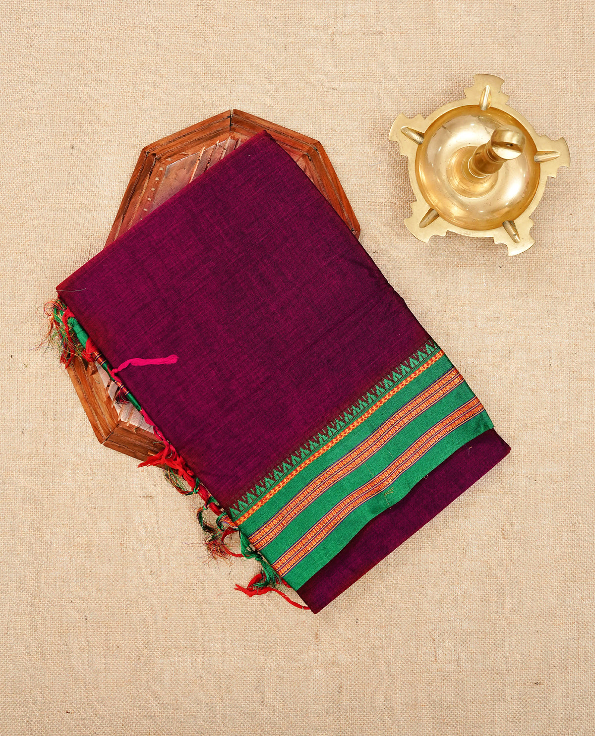Purple & Magenta dual shade Narayanapattu cotton saree with a plain body, complemented by a green Colour with border with elegant gold zari  & green colour temple designed detailing and a contrast striped pallu, paired with a matching blouse piece.