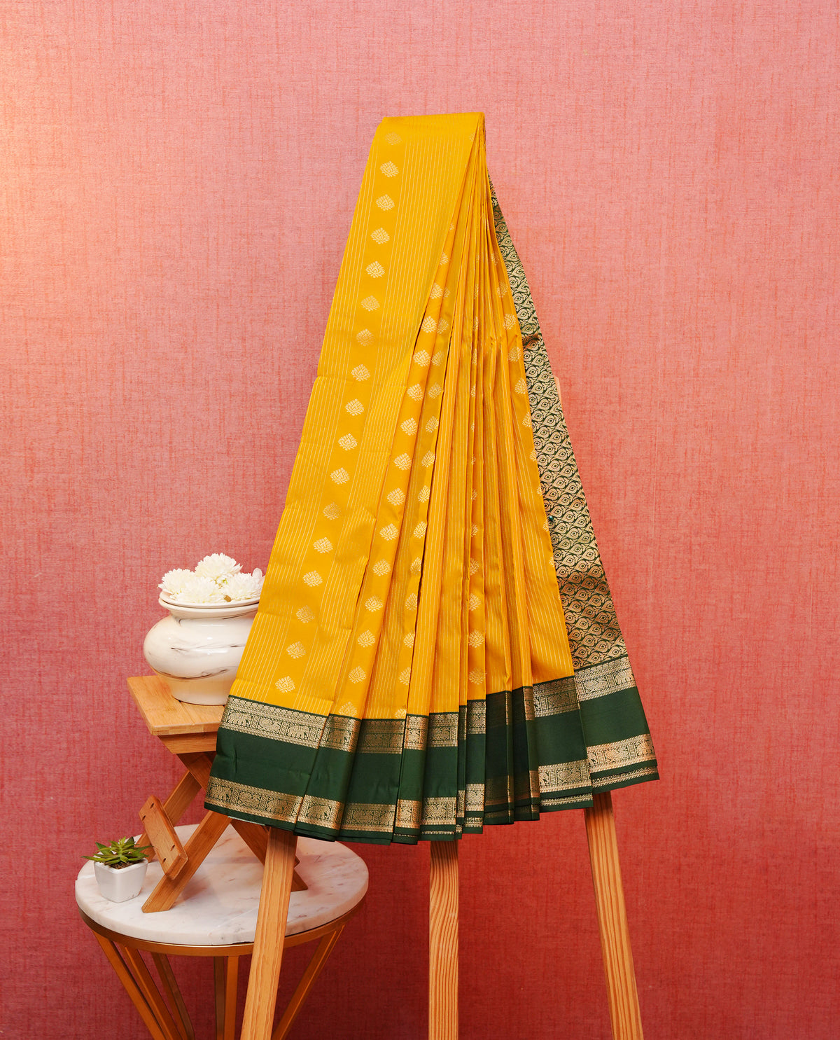Yellow colour soft silk saree featuring gold zari stripes with motifs on body, contrast dark green colour elephant & peacock motifs on border, grand pallu comes with matching blouse piece.