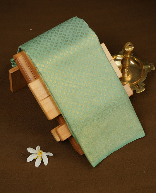 Ice green colour semi soft silk saree featuring gold zari motifs on across body, self colour border with traditional gold zari pattern, pallu and paired with matching blouse.