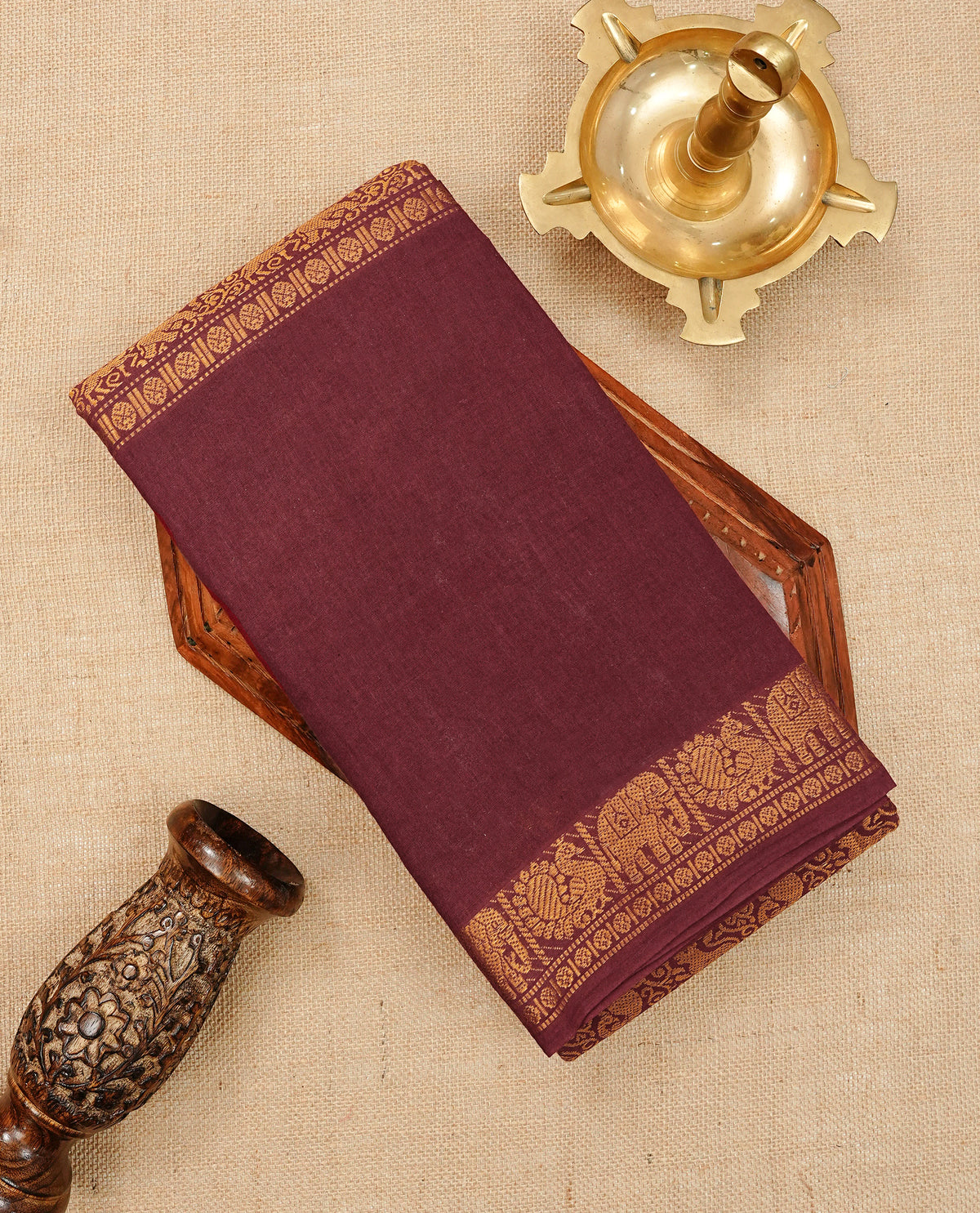 Maroon Colour Sungudi Cotton Saree with gold zari elephant & Peacock motifs on the body, a self zari border, and a rich gold zari pallu. Paired with a Contrast Beige colour blouse Piece featuring a gold zari border.