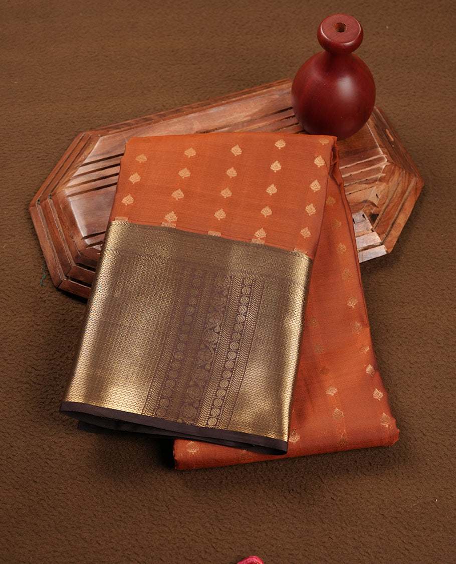 Burned orange colour Soft silk saree featuring gold zari motifs on the body, complemented by a contrast chocolate brown traditional zari border and pallu, paired with a matching blouse piece.