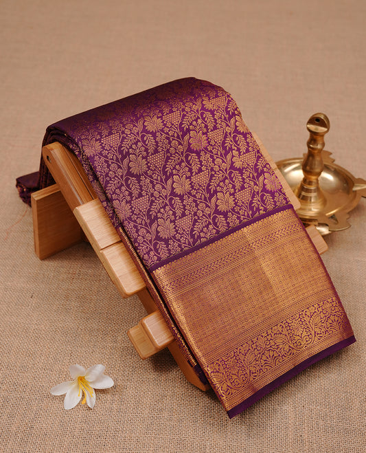 Purple colour kancheepuram silk saree featuring gold zari floral kodi pattern on body, complemented by self colour with traditional border, paired with matching blouse piece.