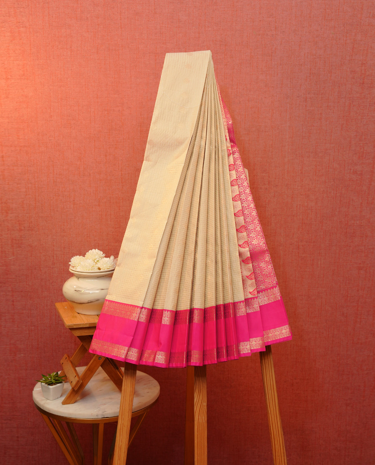 Beige colour soft silk saree featuring gold zari checks with floral motifs on body, contrast magenta colour gold zari traditional border, grand pallu comes with matching blouse piece.