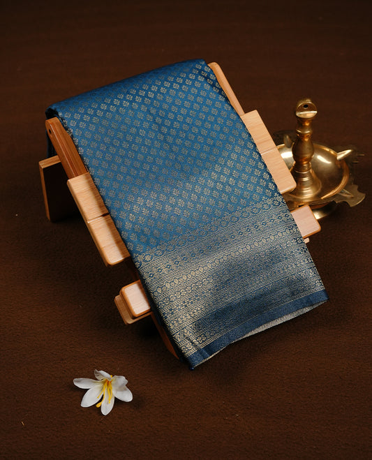 Navy blue colour soft silk saree featuring gold zari pattern on body, complemented by self colour with traditional border, paired with matching blouse piece.