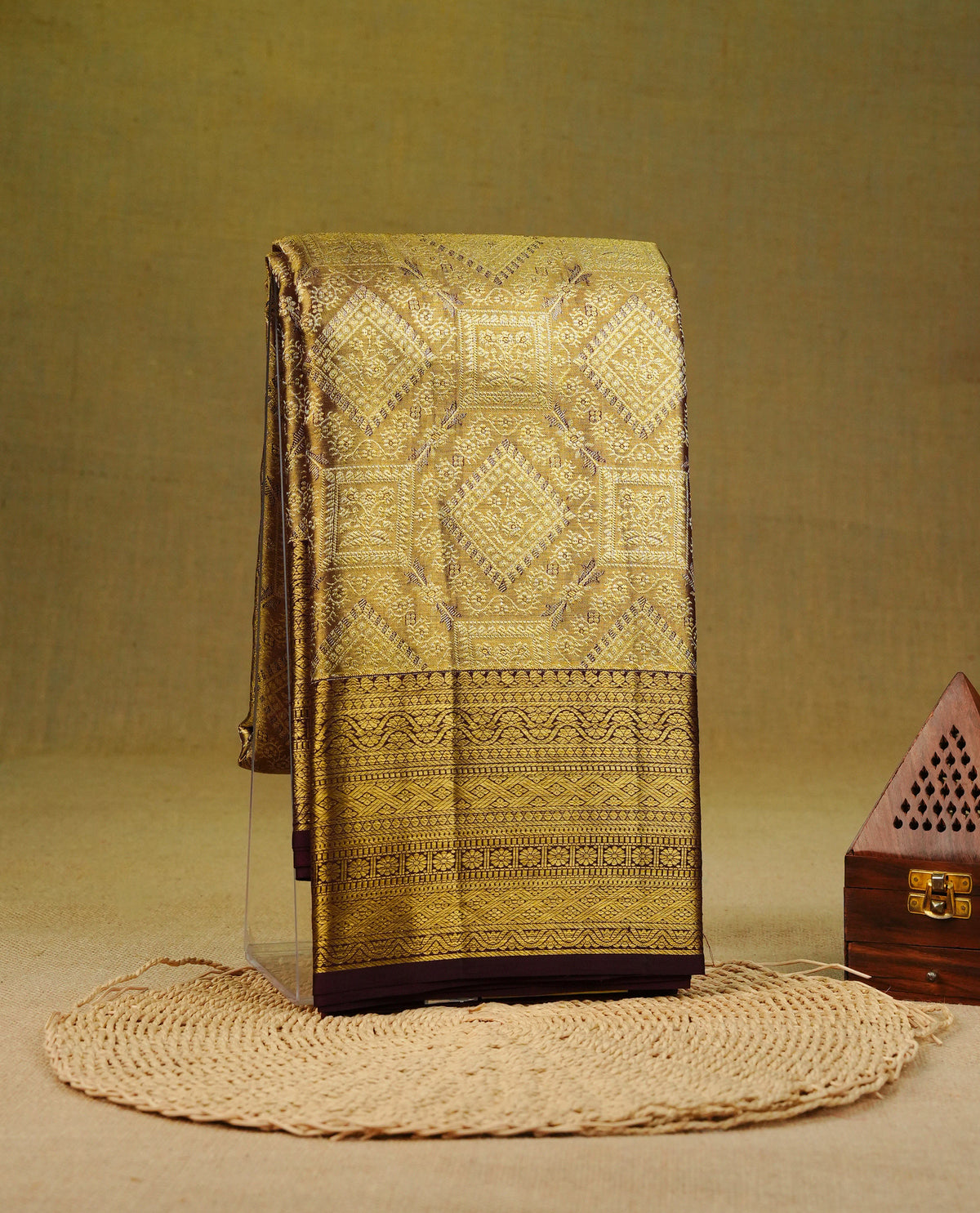 Gold colour pure tissue silk saree featuring gold zari geometric pattern on body, complemented by contrast Chocolate colour with traditional border, comes with matching blouse piece.