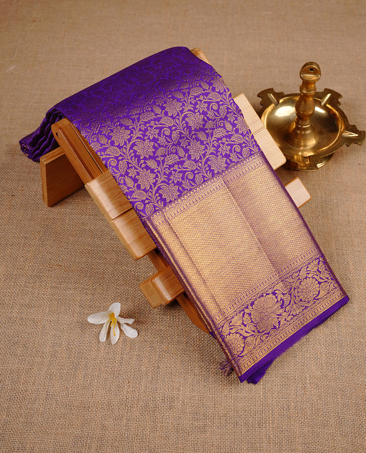Indigo colour kancheepuram silk saree featuring gold zari pattern across body, complemented by selfcolour border traditional zari border, paired with matching blouse piece.
