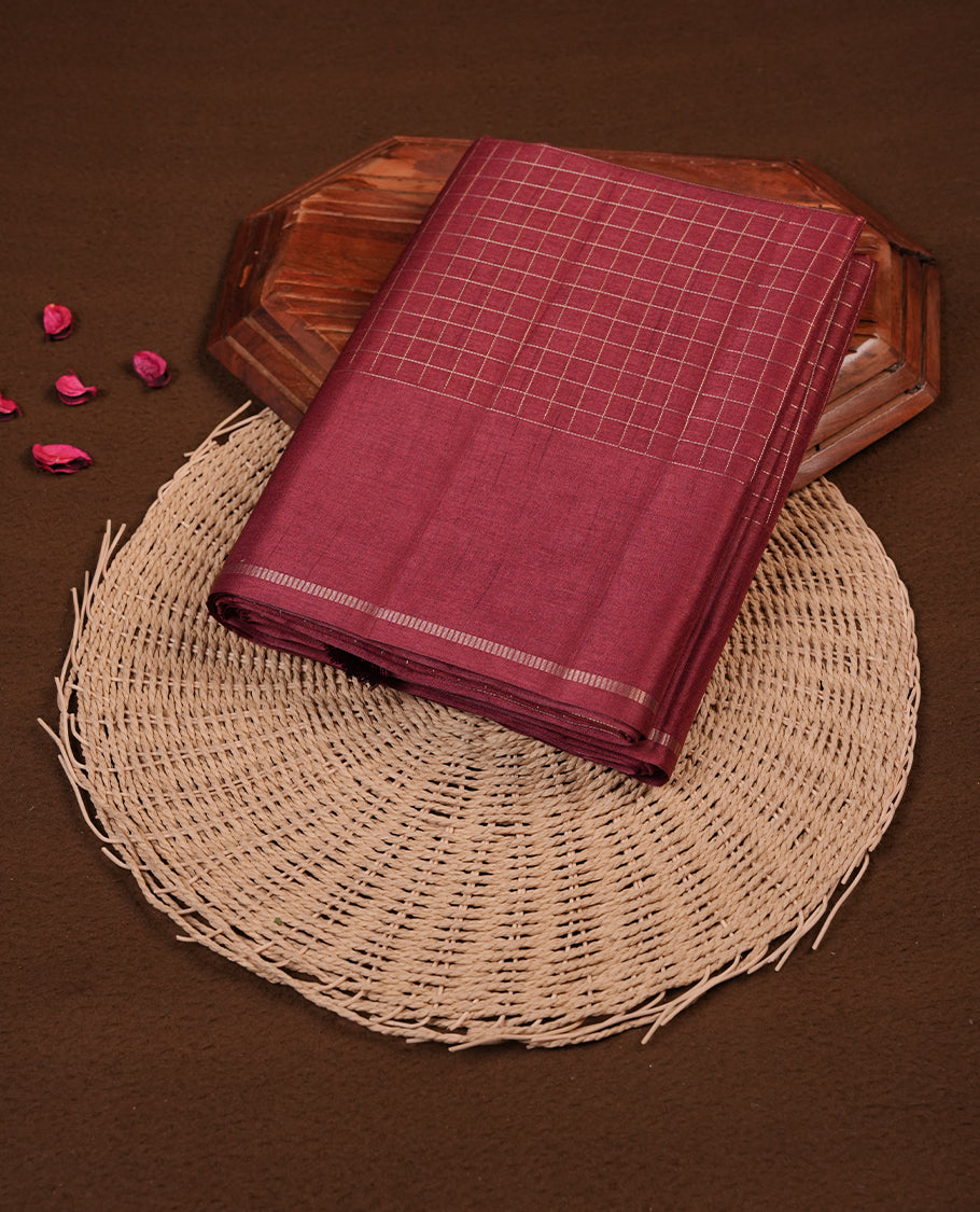 Brown colour semi tussar saree highlights gold zari check pattern across body,  border, pallu and paired with matching blouse piece.