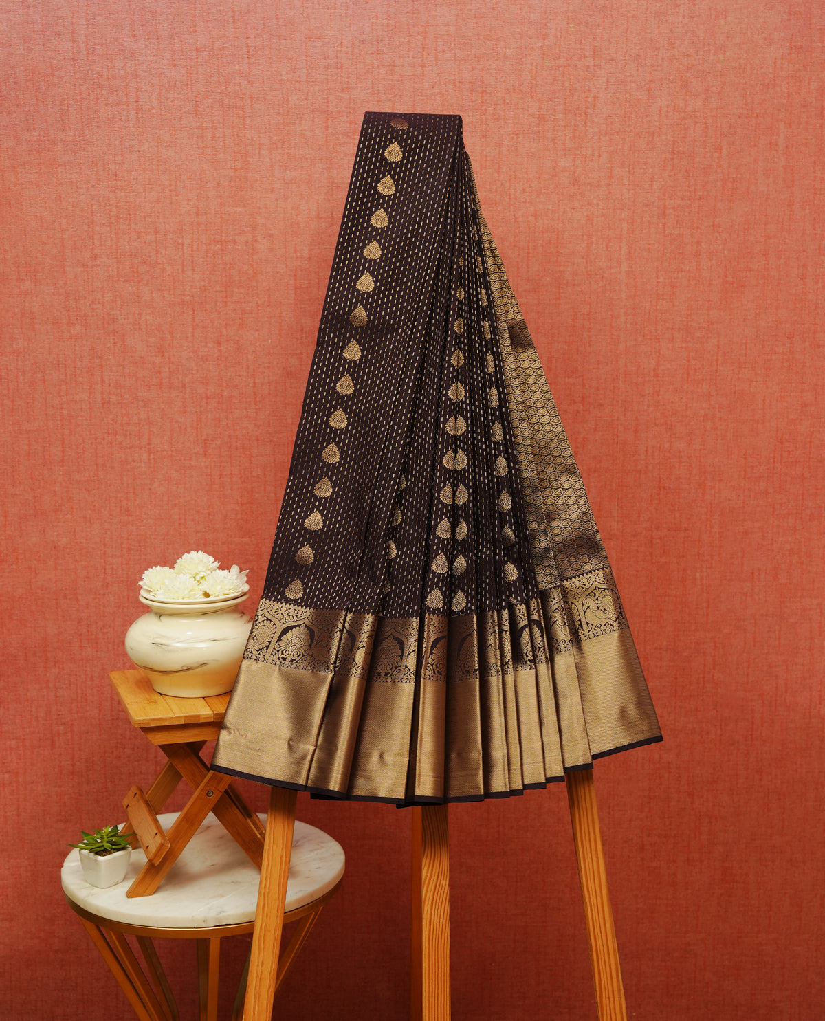 Dark chocolate colour soft silk saree featuring gold zari stripes with floral motifs on body,contrast  by self colour gold zari peacock & floral traditional border, grand pallu comes with matching blouse piece.