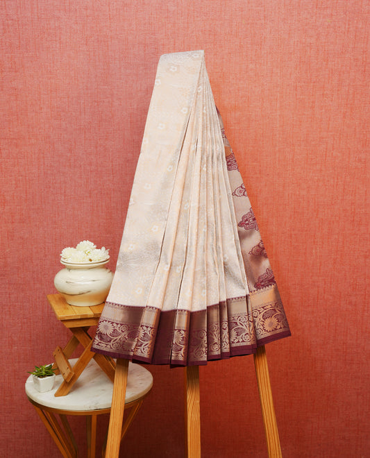 Off white colour silk saree featuring gold zari floral patterns on body, contrast maroon with gold zari traditional border, contrast grand pallu comes with matching blouse piece .