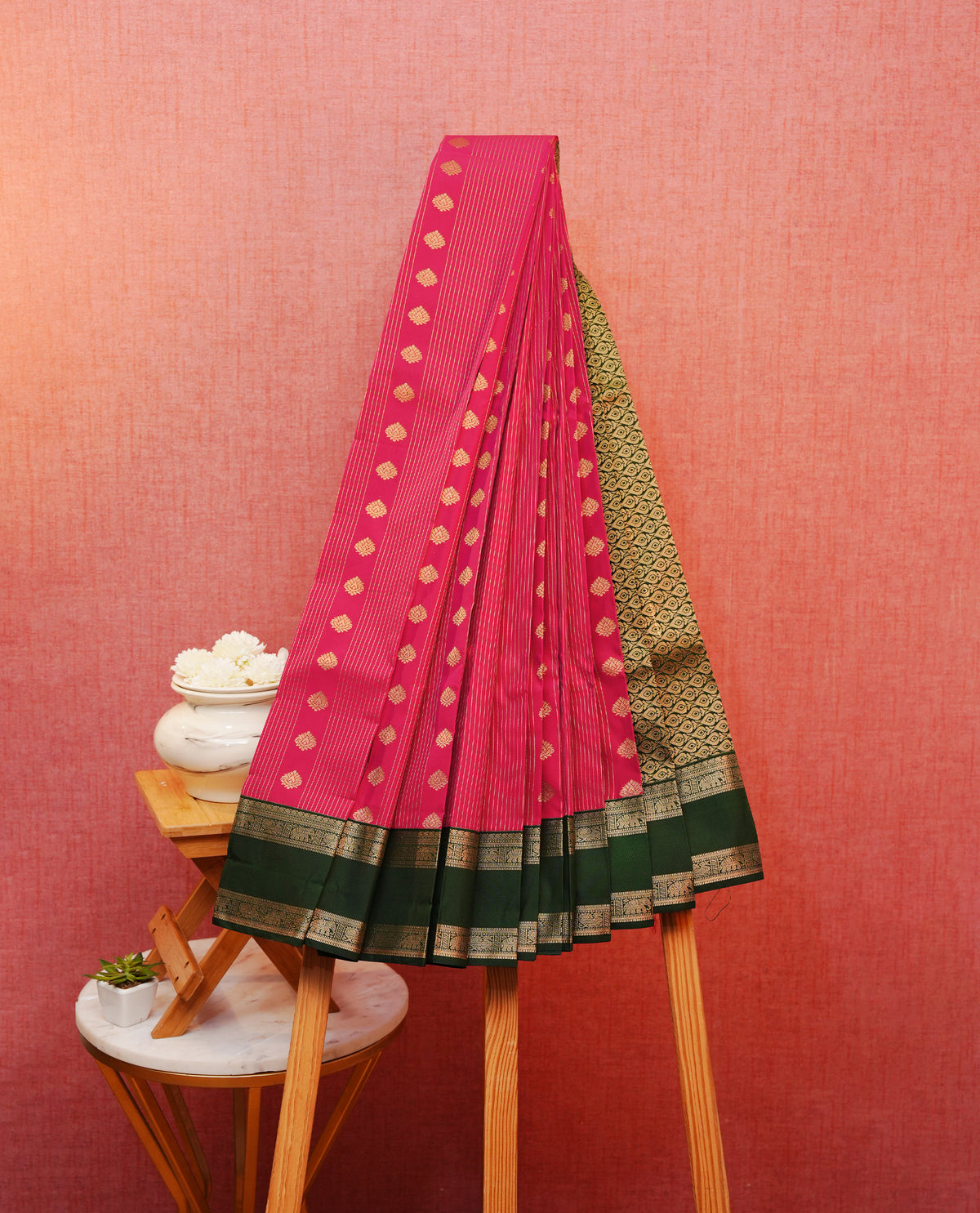 Dark pink colour soft silk saree featuring gold zari stripes florals on body, contrast dark green colour gold zari elephant & peacock motifs on border, grand pallu comes with matching blouse piece.