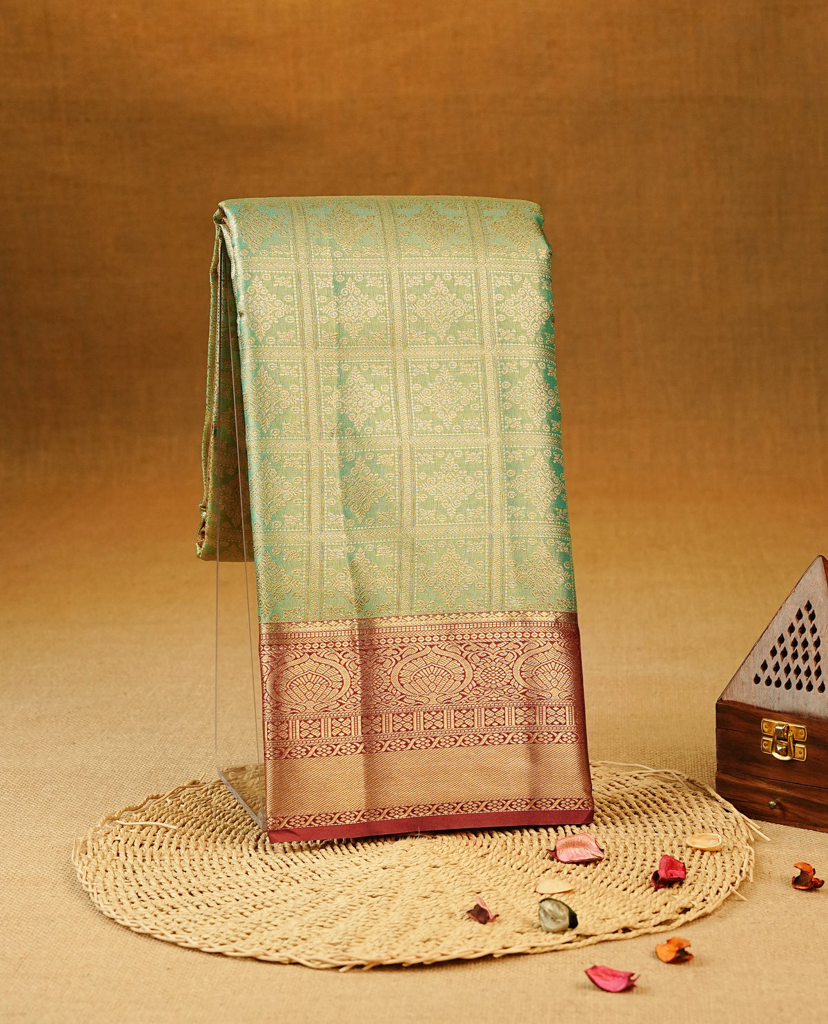 Green colour Semi Tissue Silk Saree featuring gold zari Works on the body, complemented by an intricately woven gold zari pallu, a rich Maroon border with gold zari work and paired with a matching plain blouse piece.