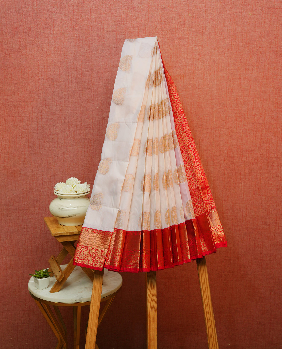 Cream colour silk saree featuring gold zari mango motifs on body, contrast red with gold zari traditional border, contrast grand pallu comes with matching blouse piece .