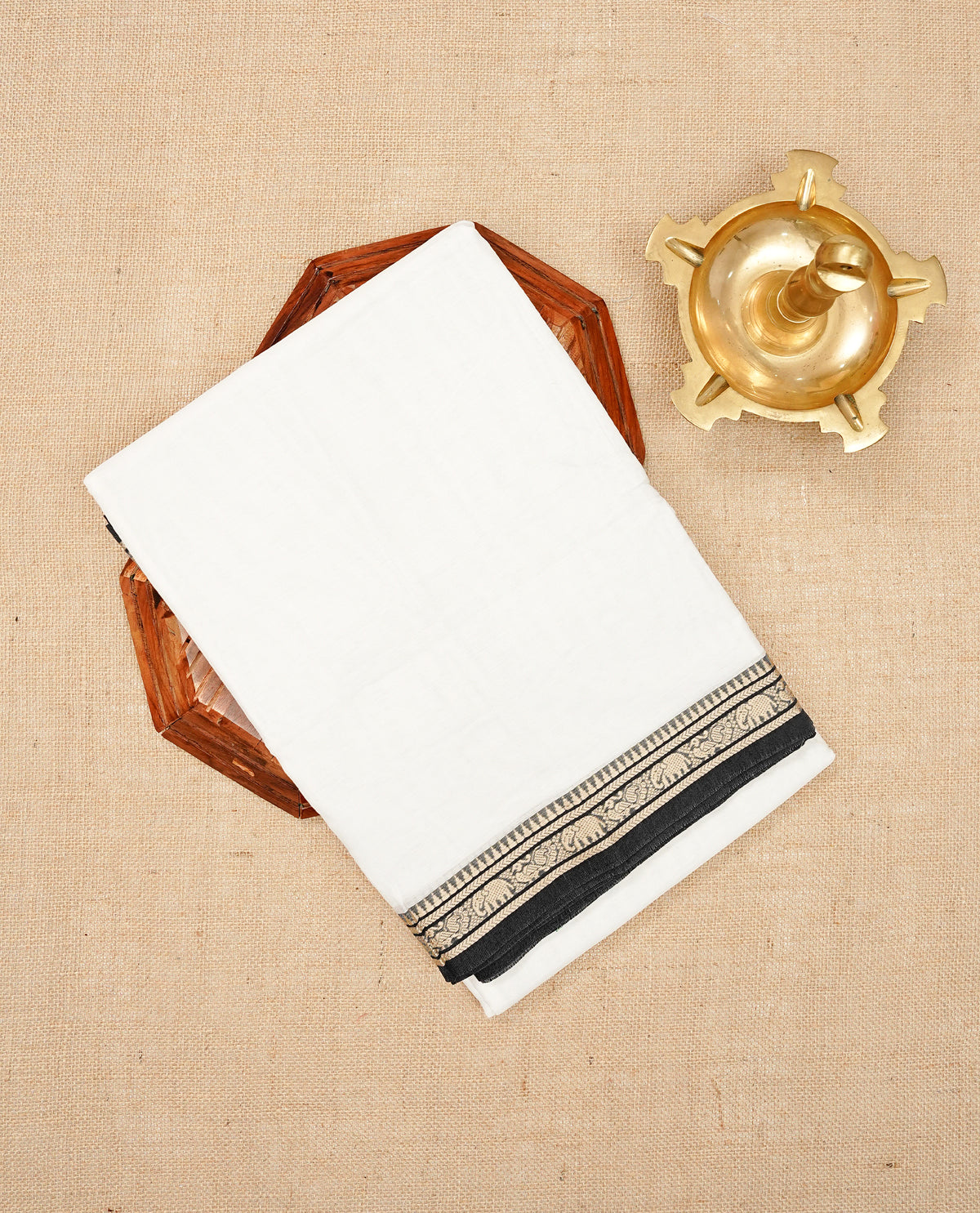 Off White colour Narayanapattu cotton saree with a plain body, complemented by a Black colour border featuring beige peacock and elephant motifs & a contrast pallu, paired with a matching blouse piece.