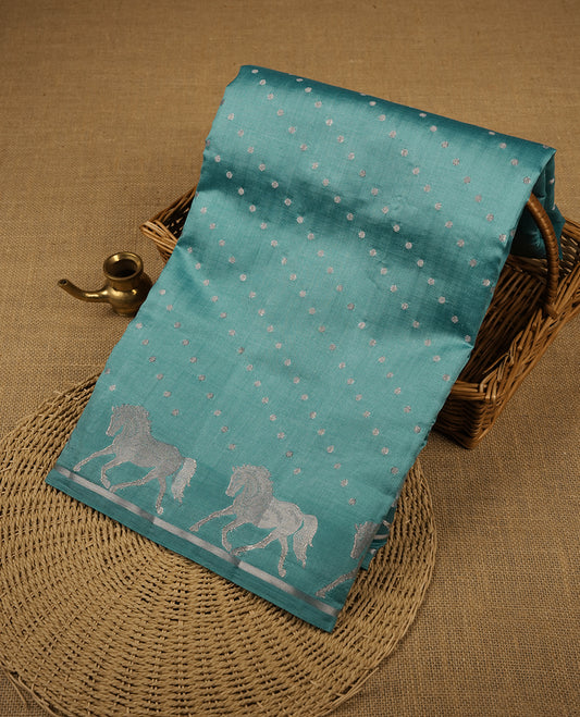 Pastal blue colour banaras soft silk saree featuring silver zari dotted stripes on body, self colour border with silver horse pattern, pallu and paired with matching blouse.