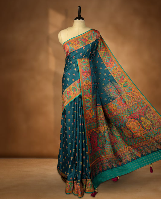 Crystal Teal colour Pashmina silk saree densely woven with intricate multicolour floral and architectural motifs across the body, framed by an opulent arabesque border and grand storytelling pallu, paired with a matching black woven border blouse piece