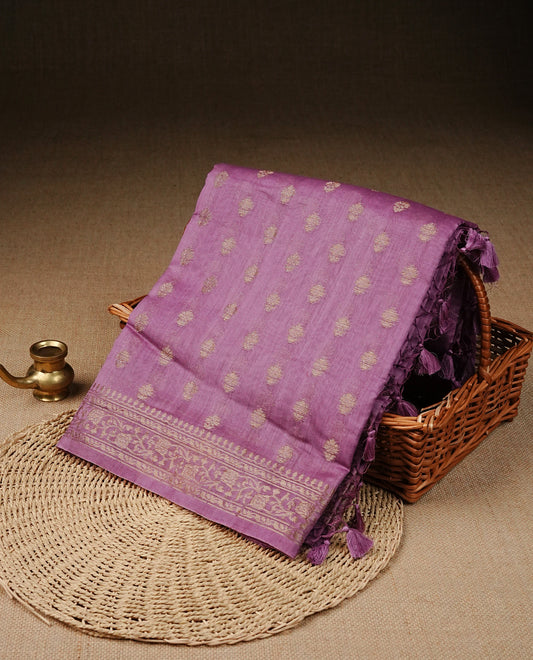 mauve  colour Tussar Silk saree featuring antique zari butta motifs on the body, enhanced with a self-coloured floral Gold zari border and  pallu, paired with a matching blouse piece.