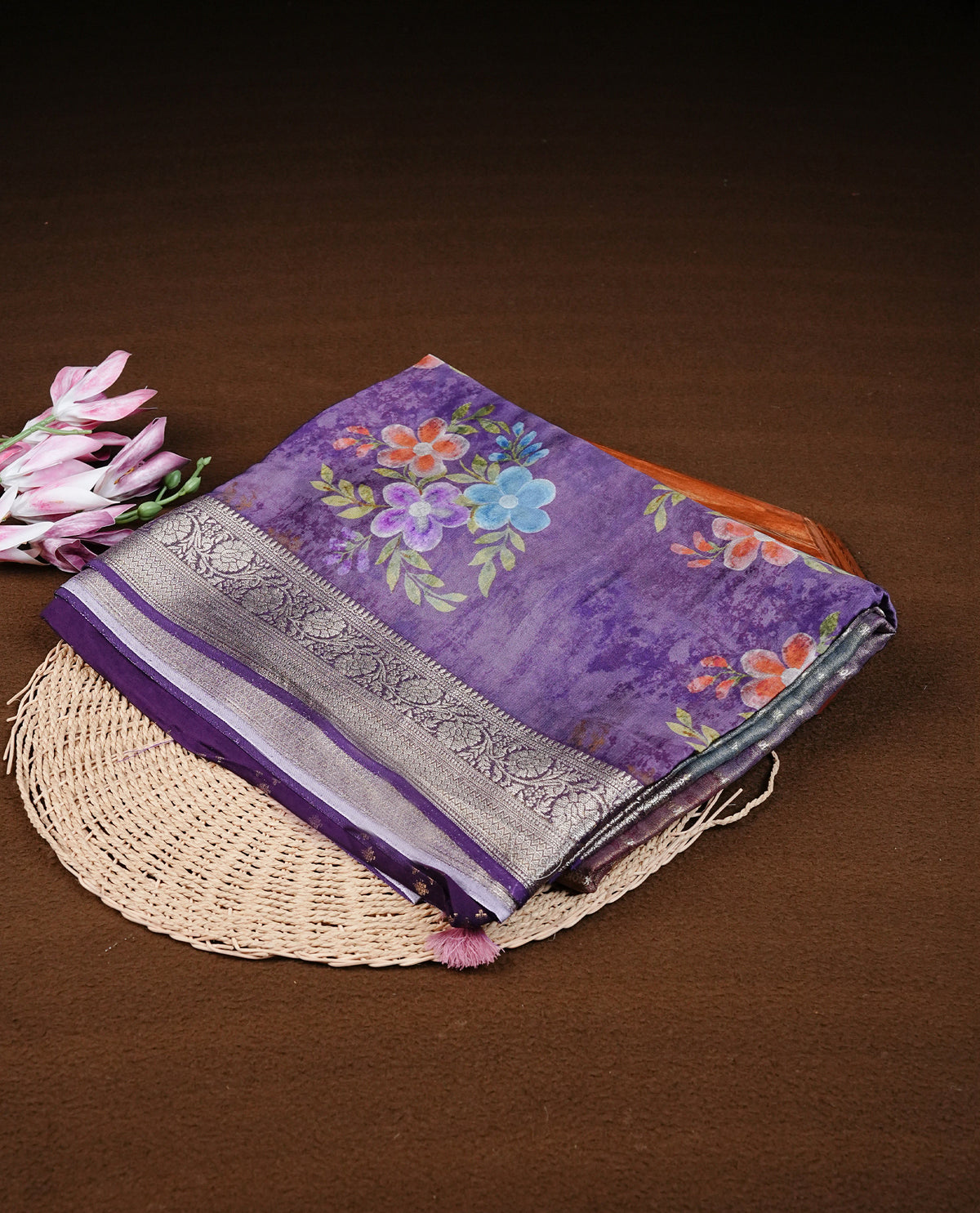 Purple colour banaras silk saree featuring Floral print on body, complemented by Light gold zari border with striped pallu, comes with matching blouse piece.