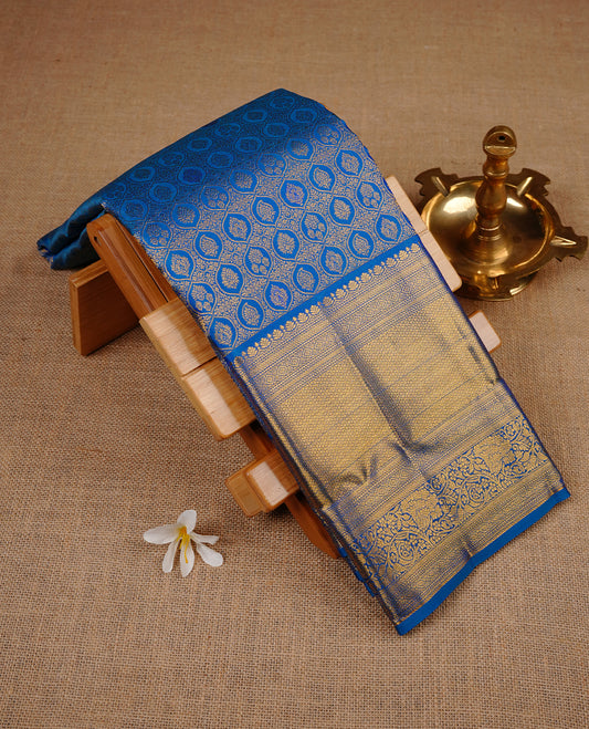 Blue colour kancheepuram silk saree featuring gold zari pattern across body, complemented by selfcolour border traditional zari border, paired with matching blouse piece.