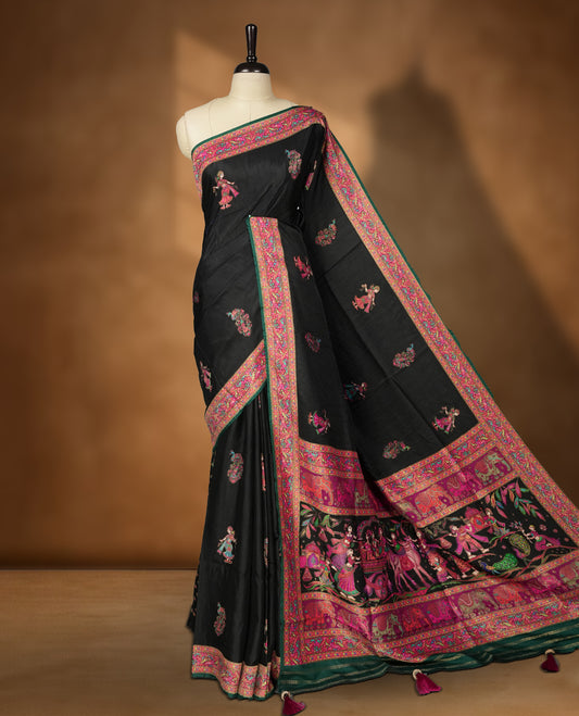Black Pashmina Silk Saree with Intricate Embroidered Buti Work on Body, Detailed Multicolor Depictions of Royal Processions and Dancers on Vibrant Pink-Green Zari Border & Grand Pallu, Paired with Matching Blouse Piece