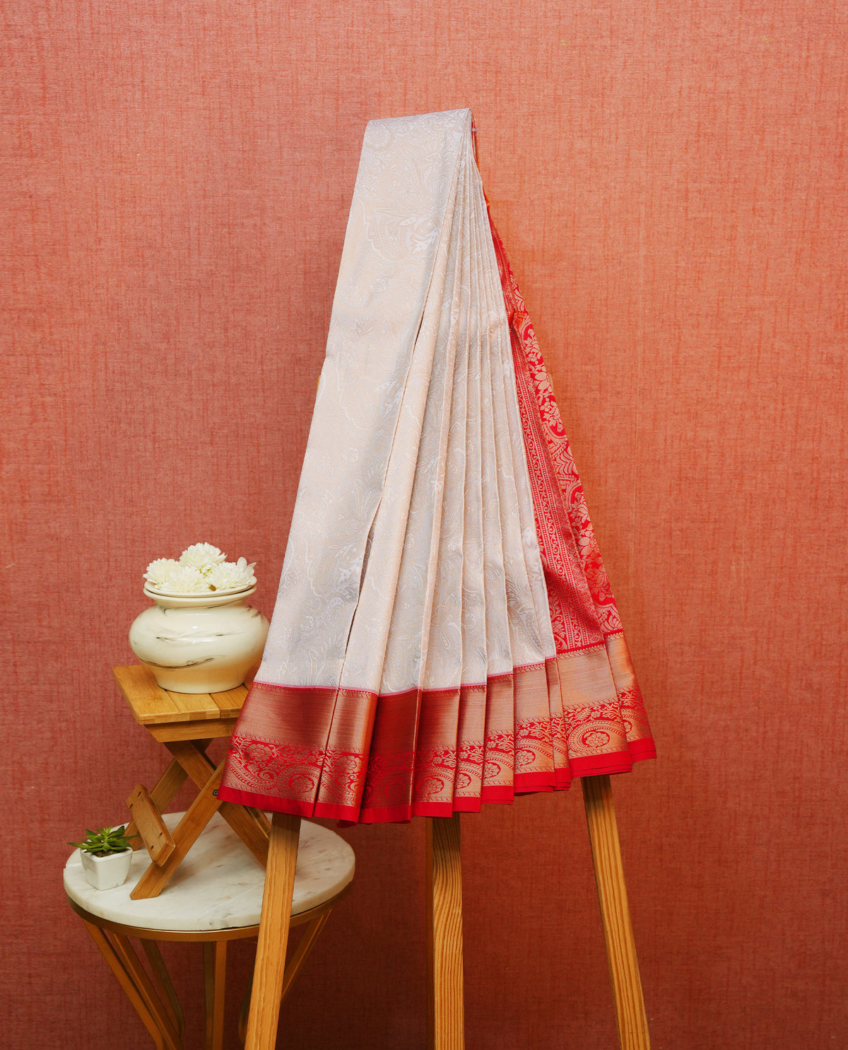 Off white colour silk saree featuring gold zari floral patterns on body, contrast red with gold zari traditional border, contrast grand pallu comes with matching blouse piece .