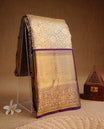 Gold colour kancheepuram tissue silk saree featuring gold zari pattern across body, complemented by contrast purple colour border traditional zari border, paired with matching blouse piece.