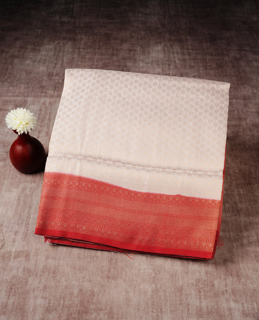 Cream colour softie silk saree featuring gold zari floral pattern brocade body, with contrasting red colour colour border.paired with matching blouse piece.