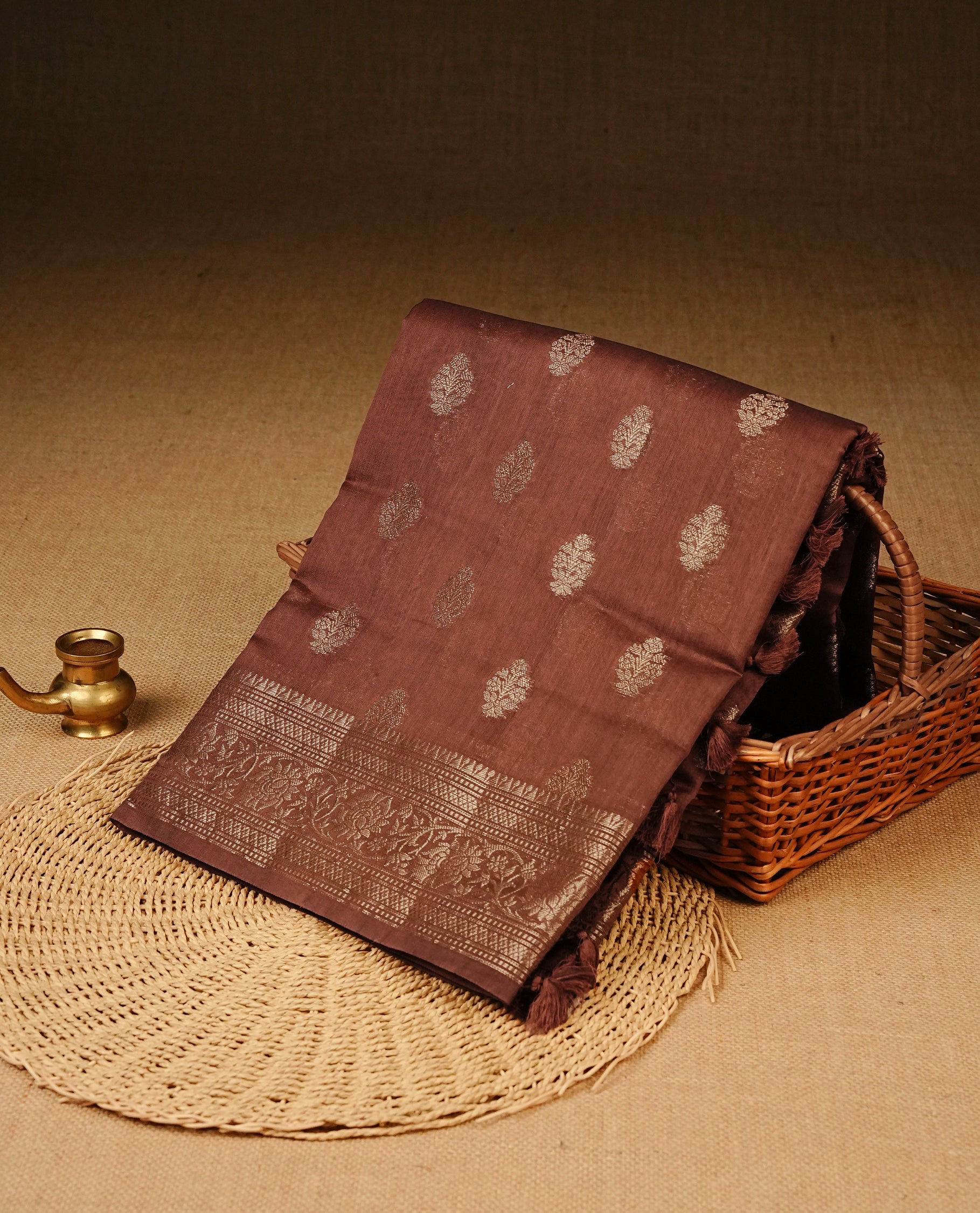 Brown colour Tussar Silk saree featuring elegant antique zari butta motifs on Body , complemented by a self-coloured floral Gold zari border and pallu, paired with a matching blouse piece.
