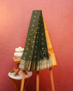 Dark green colour soft silk saree featuring gold zari lines with elephant motifs on body, contrast Mustard yellow colour gold zari peacock motifs on border, grand pallu comes with matching blouse piece.