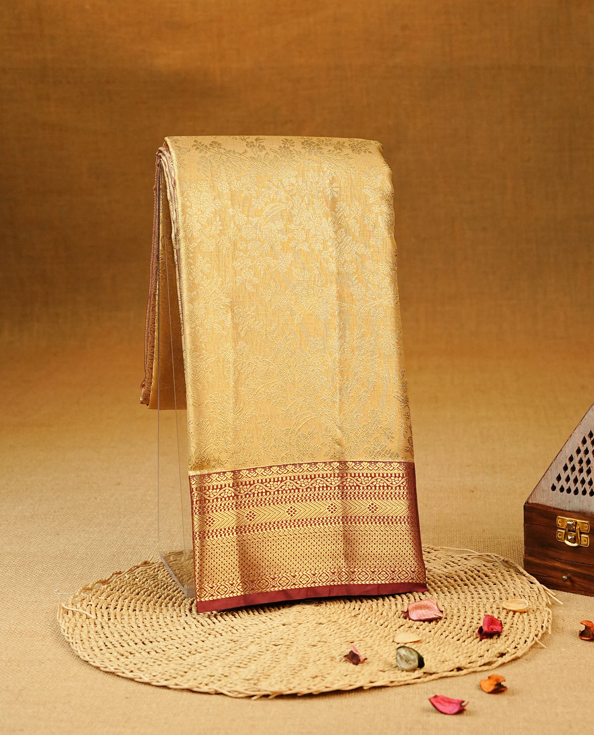Light Gold colour Semi Tissue Silk Saree featuring gold zari Works on the body, complemented by an intricately woven gold zari pallu, a rich Maroon border with gold zari work and paired with a matching plain blouse piece.