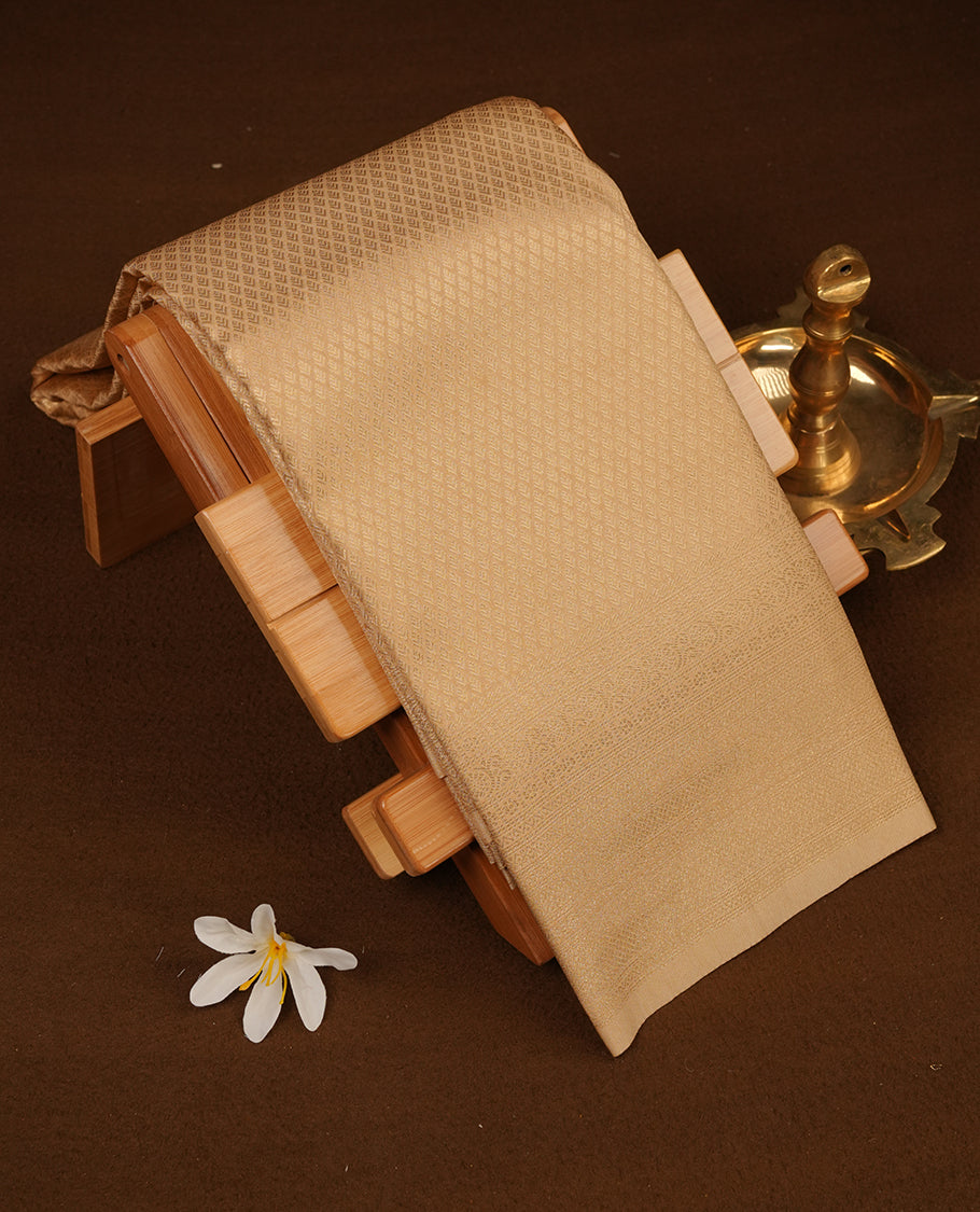 Light gold colour semi soft silk saree featuring gold zari motifs on across body, self colour border with traditional gold zari pattern, pallu and paired with matching blouse.