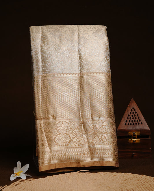 Light Gold colour semi tissue silk saree featuring silver zari pattern on body, contrast gold colour with gold zari traditional border, paired with matching blouse piece.