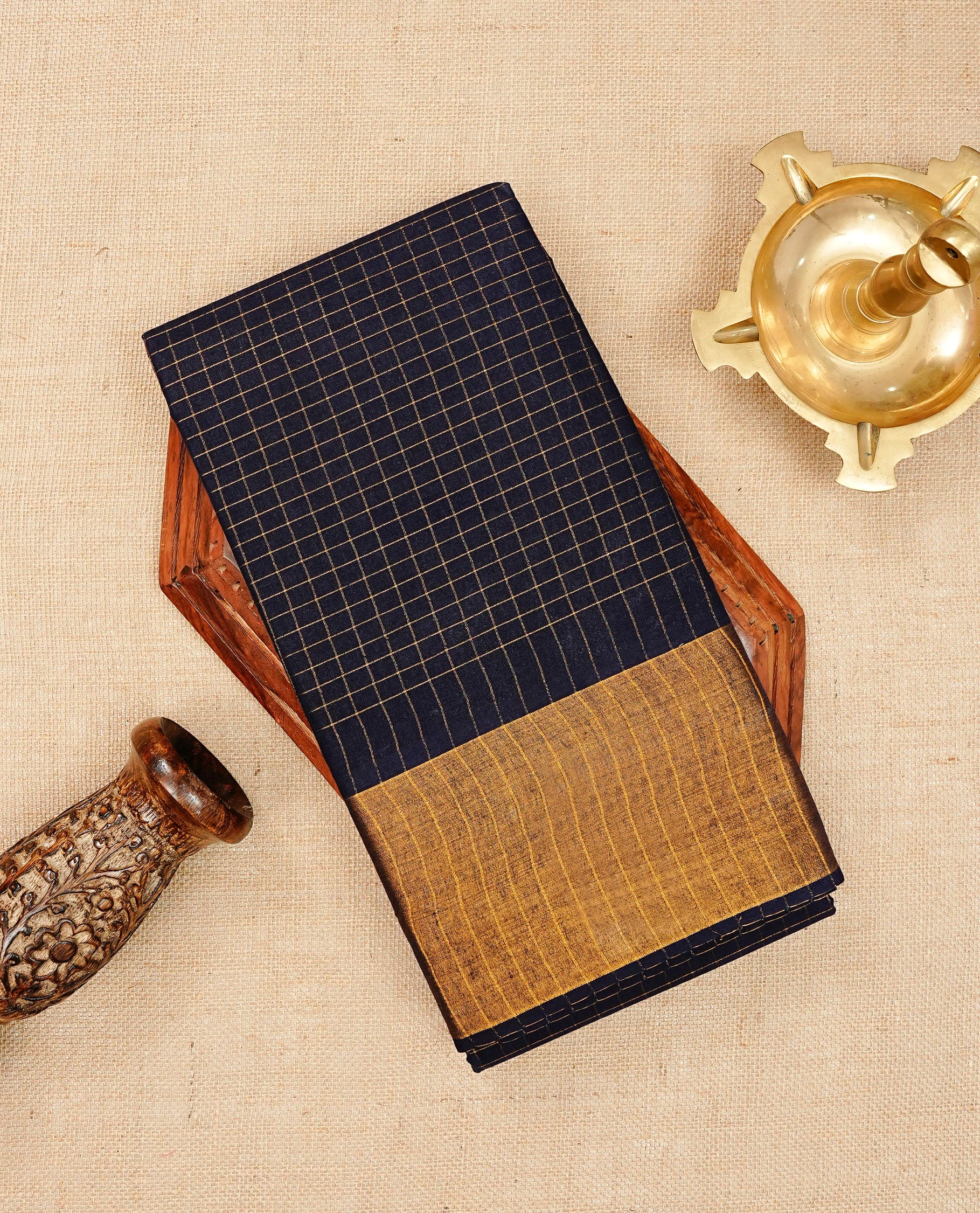 Navy blue colour Sungudi cotton saree featuring elegant gold zari checks across the body, complemented by a contrast gold zari border. Comes with a matching blouse piece.