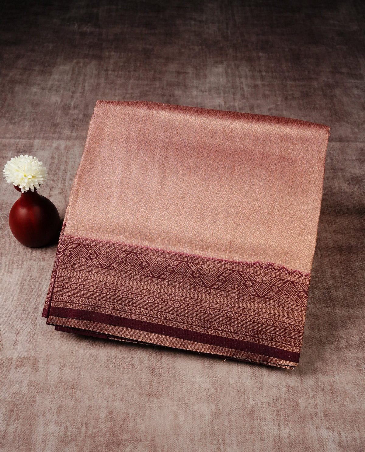 dusty peach colour softie silk saree featuring gold zari, rich pallu floral pattern brocade body, with contrasting maroon colour border.paired with matching blouse piece.