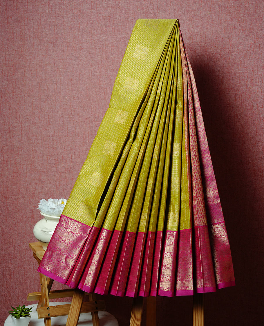 Lemon coloured soft silk saree featuring gold zari stripes and motifs across the body, enhanced with a contrast Magenta border and pallu, paired with a matching contrast blouse piece.