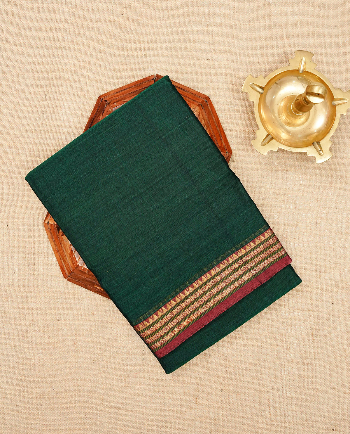 Bottle green colour Narayanapattu cotton saree with a plain body, complemented by a Dark red colour with Gold Zari border & contrast pallu, paired with a matching blouse piece