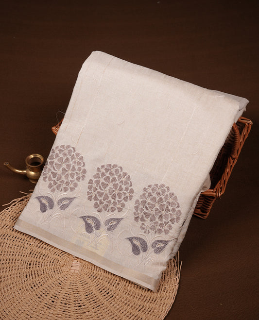Beige colour Tussar silk saree featuring Elegant plain body, highlighting Grey colour floral cut work with Light gold zari border, pallu and paired with matching blouse piece.
