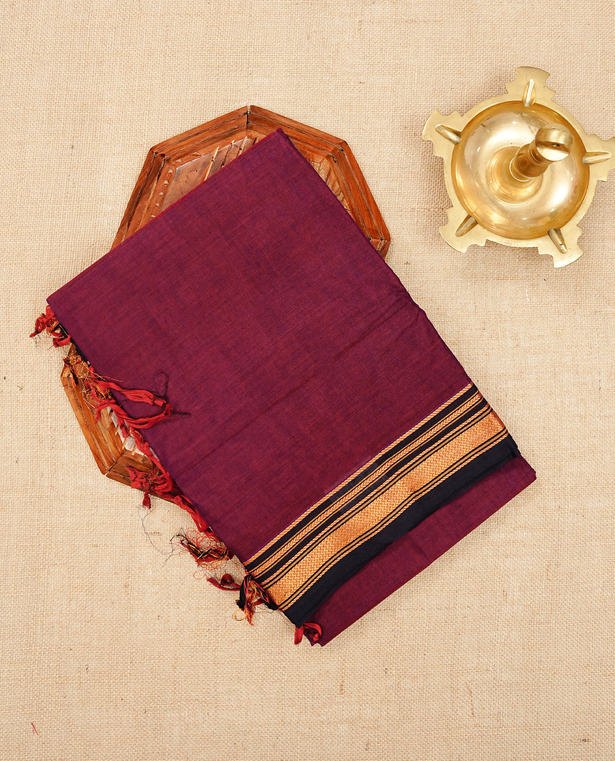 Wine colour Narayanapattu cotton saree with a plain body, complemented by a dark chocolate brown border with elegant gold zari detailing and a contrast striped pallu, paired with a matching blouse piece.