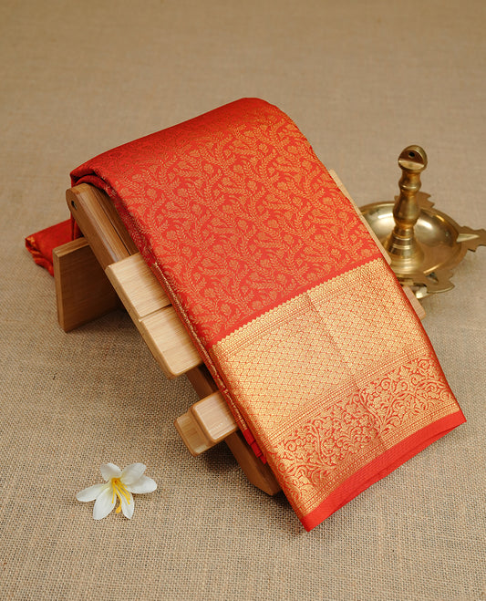 Red colour kancheepuram silk sareee featuring gold zari floral kodi pattern on body, complemented by self colour with traditional border, paired with matching blouse piece.