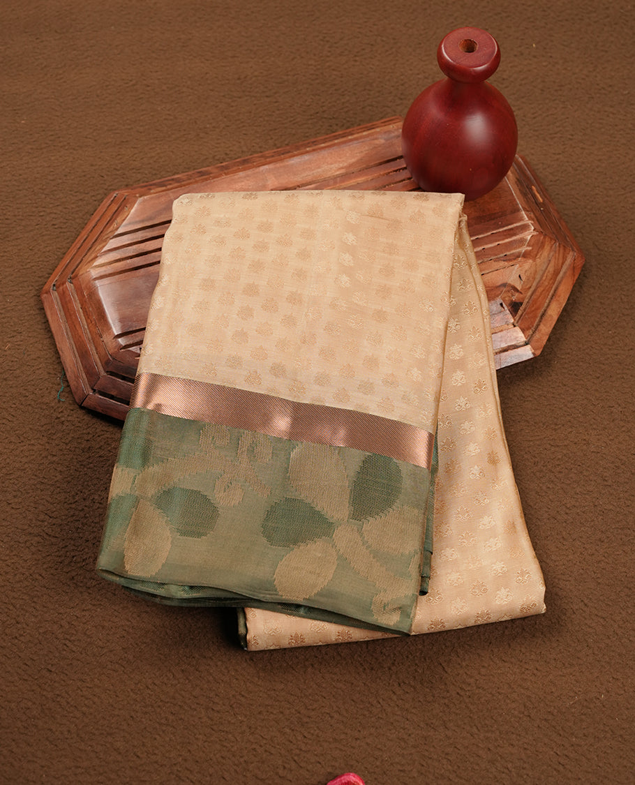 Light gold colour soft silk saree featuring gold zari motifs on the body, complemented by a contrast green zari floral kodi border and pallu, paired with a matching blouse piece.