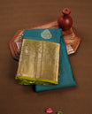 Teal colour soft silk saree featuring gold zari motifs on the body, complemented by a contrast Green traditional zari border and pallu, paired with matching blouse piece.