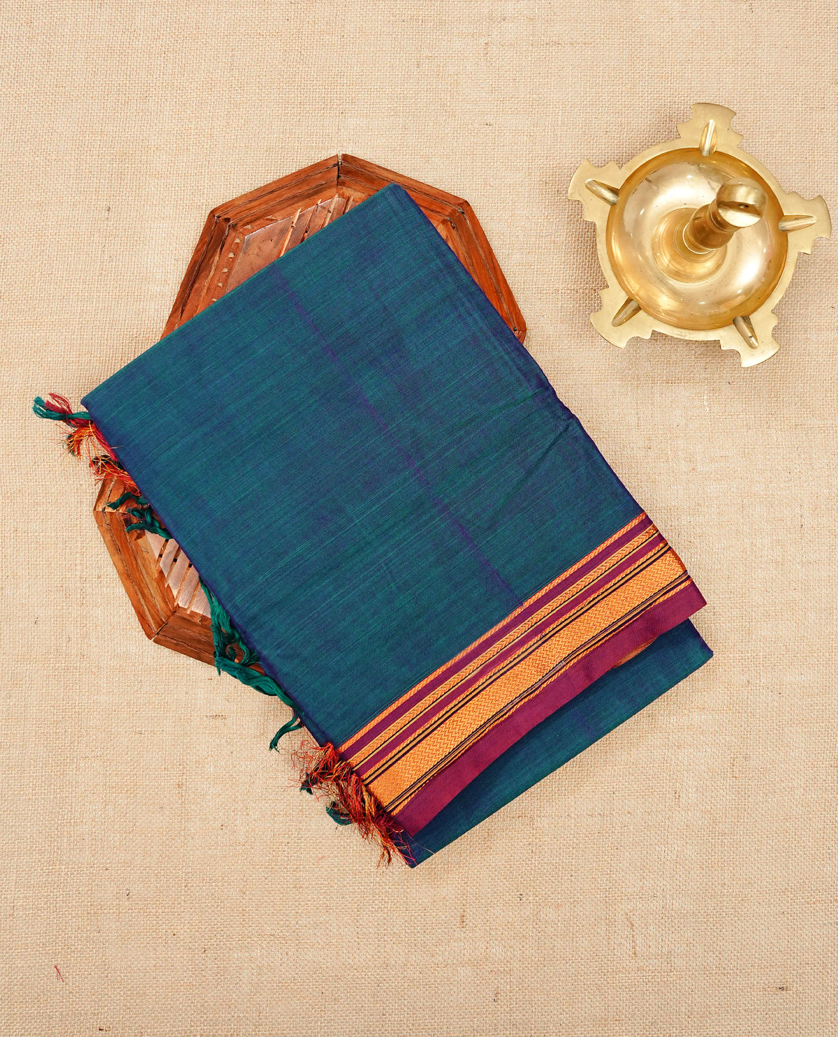 Peacock Blue colour Narayanapattu cotton saree with a plain body, complemented by a wine Colour with border with elegant gold zari detailing and a contrast striped pallu, paired with a matching blouse piece.