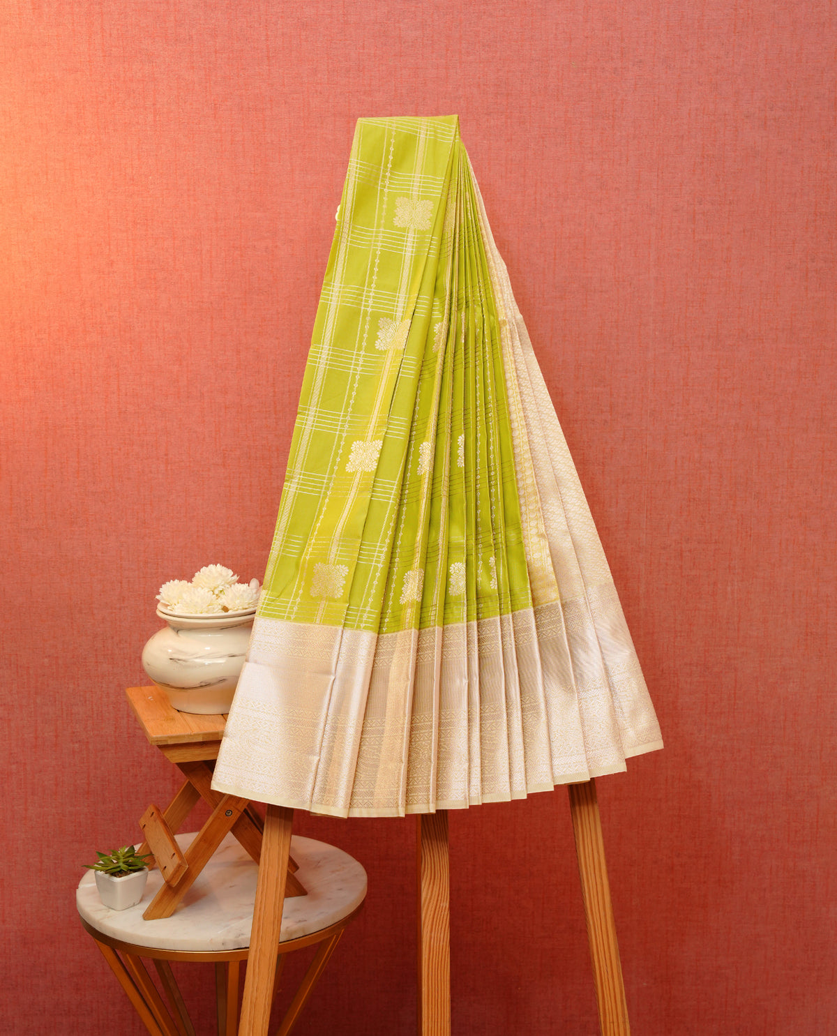 Light green colour soft silk saree featuring gold zari checks with floral mottifs on body, contrast cream colour gold zari traditional border, grand pallu comes with matching blouse piece.