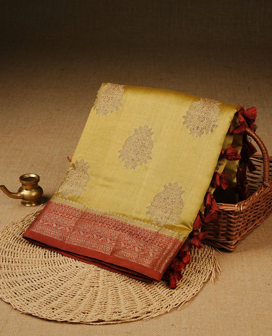 Mustard Colour Tussar Silk saree with elegant antique zari floral motifs On Body, a contrasting Brick red zari border, a rich zari pallu, Paired With a matching  blouse piece.