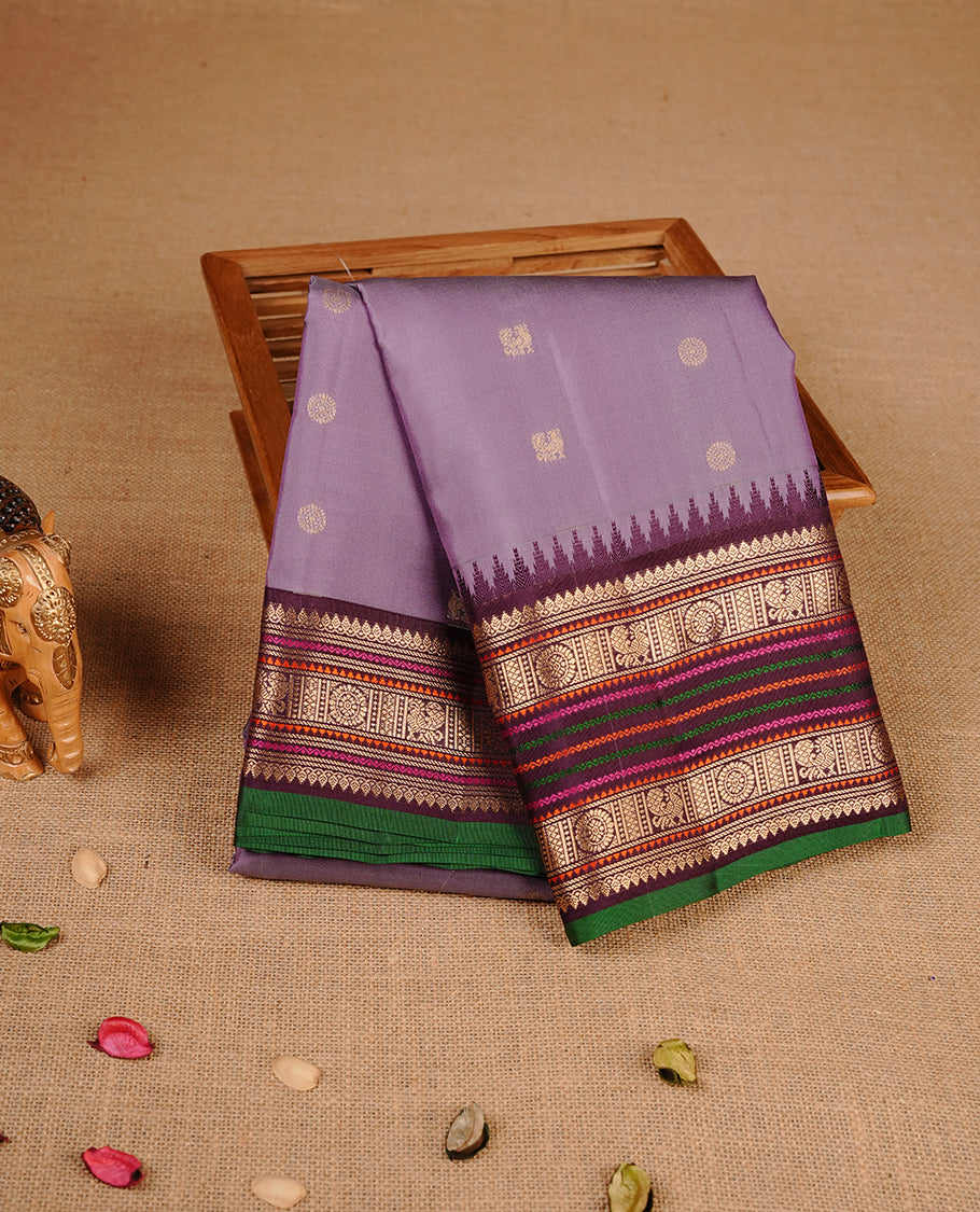 Lavender colour traditional kancheepuram silk saree featuring gold zari motifs on body, complemented by contrast multicolour with gold zari traditional border, paired with matching blouse piece.