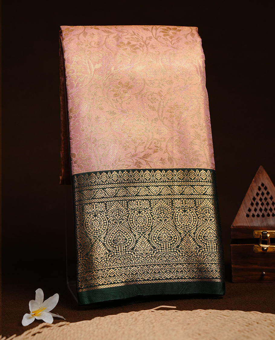 Baby pink colour semi tissue silk saree featuring gold zari floral kodi pattern on body, contrast green colour with gold zari traditional border, paired with matching blouse piece.
