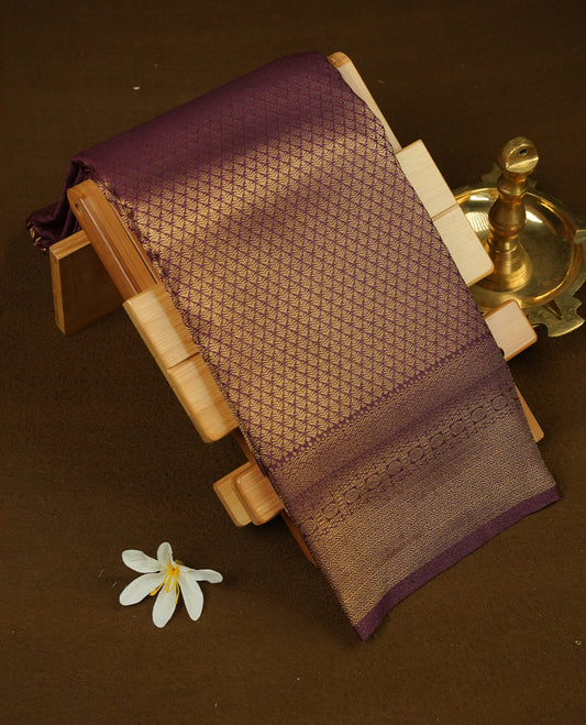 Burnt burgundy colour semi soft silk saree featuring gold zari motifs on across body, self colour border with traditional gold zari pattern, pallu and paired with matching blouse.