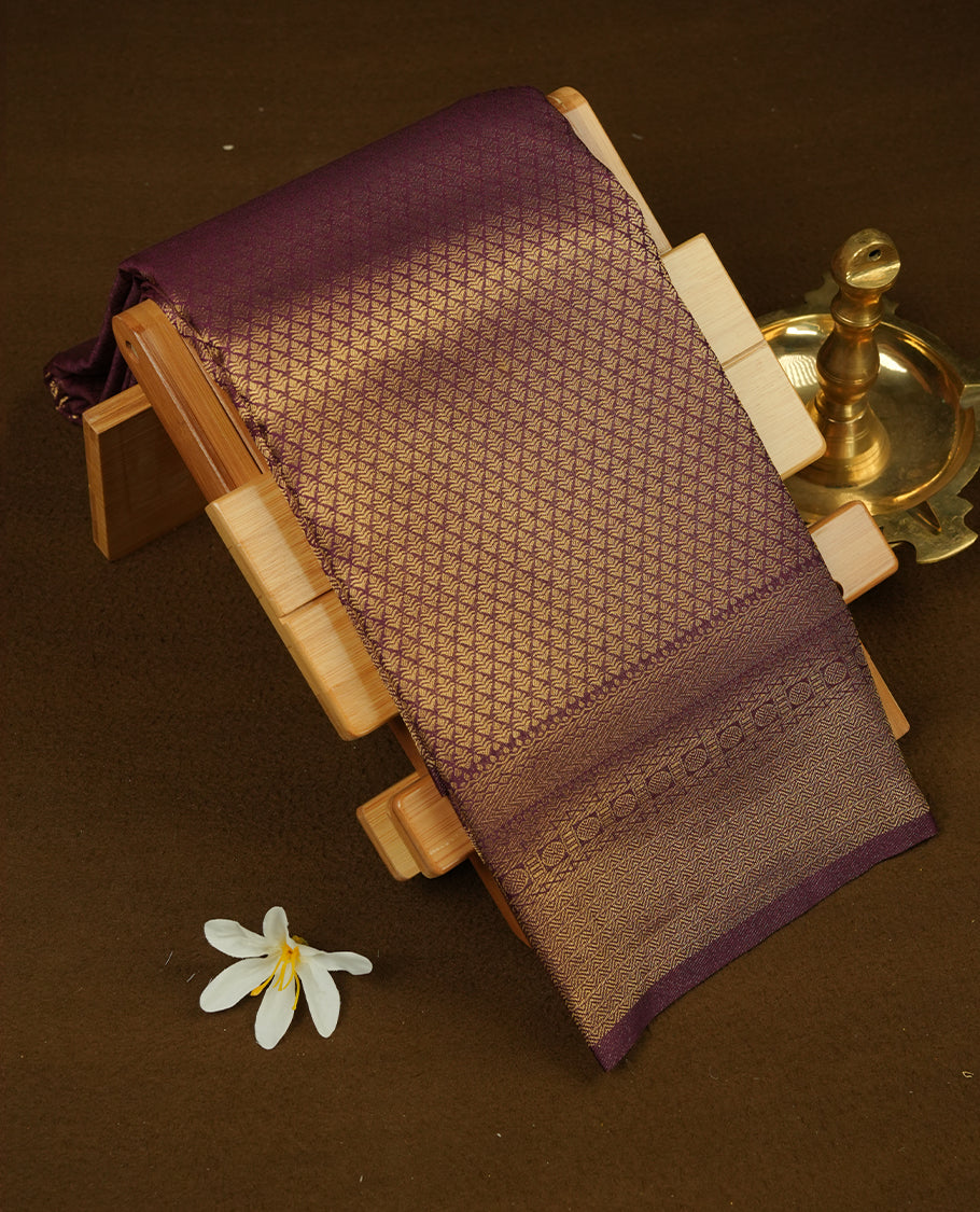 Burnt burgundy colour semi soft silk saree featuring gold zari motifs on across body, self colour border with traditional gold zari pattern, pallu and paired with matching blouse.