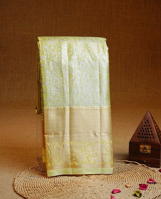 Pale Yellow colour Semi tissue silk saree featuring Silver zari kodi floral motifs on body, Self colour with traditional border, paired with matching blouse piece.