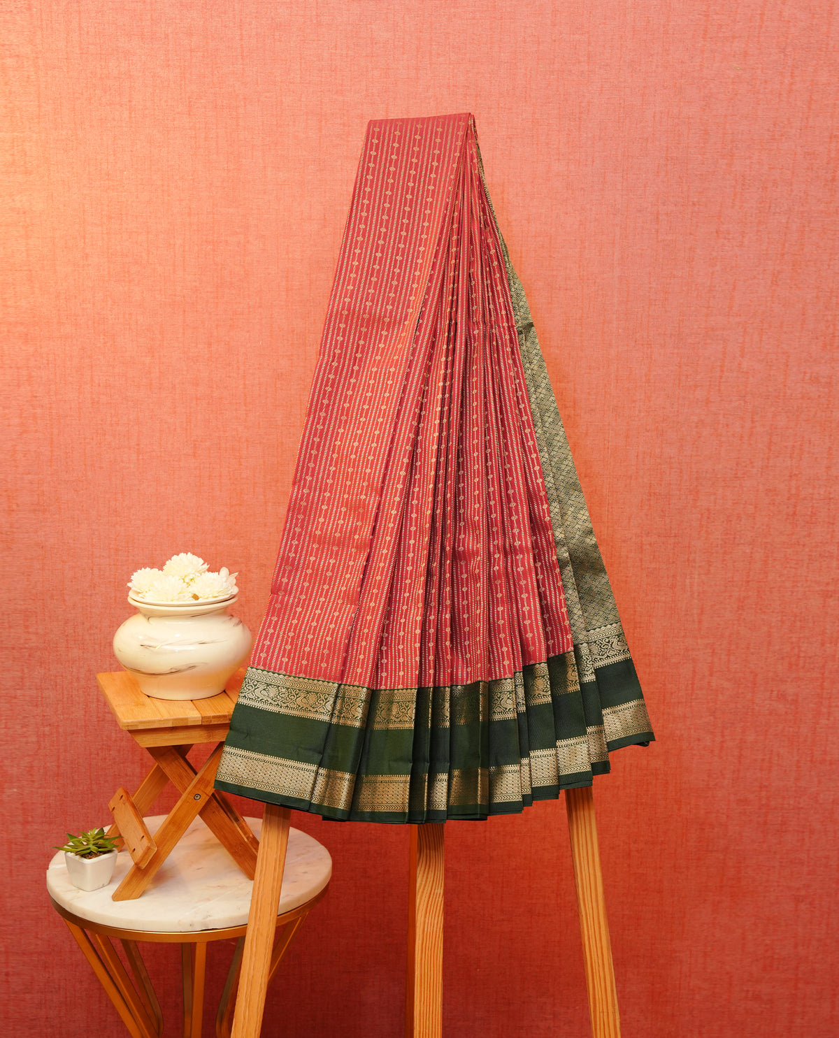 Maroon colour soft silk saree featuring gold zari stripes with buttas on body, contrast dark forest colour gold zari peacock & traditional border, grand pallu comes with matching blouse piece.