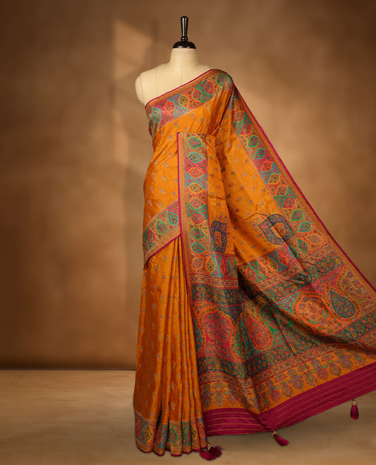 Mustard colour Pashmina silk saree densely woven with intricate multicolour floral motifs across the body, framed by an opulent arabesque border and grand storytelling pallu, paired with a matching woven border blouse piece